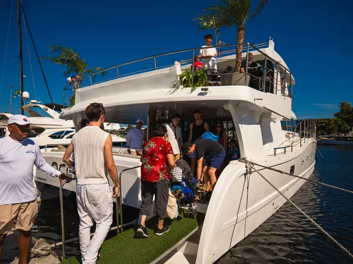 Convidados embarcando em um catamarã decorado para um evento